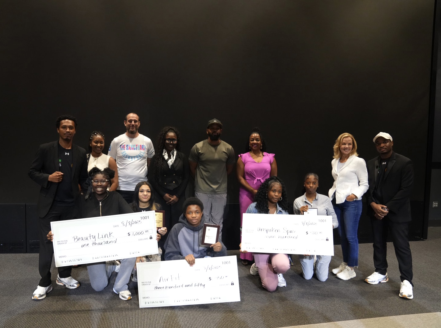 Youth founders, Flip-A-Heart leaders, and supporters celebrating with awards at Under Armour